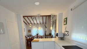 Eine moderne Küche mit weißen Schränken, einer schwarzen Arbeitsplatte und einem eingebauten Backofen.