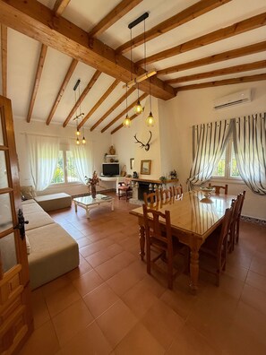 A spacious living area with a wooden dining table, comfortable seating, and a fireplace. - Casa Los Alamos with Pool, Renovated Kitchen, Wi-Fi, and Terrace (Vejer)