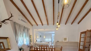 Ein Zimmer mit Kamin, Esstisch, Stühlen und einer Zierpflanzenanordnung.
