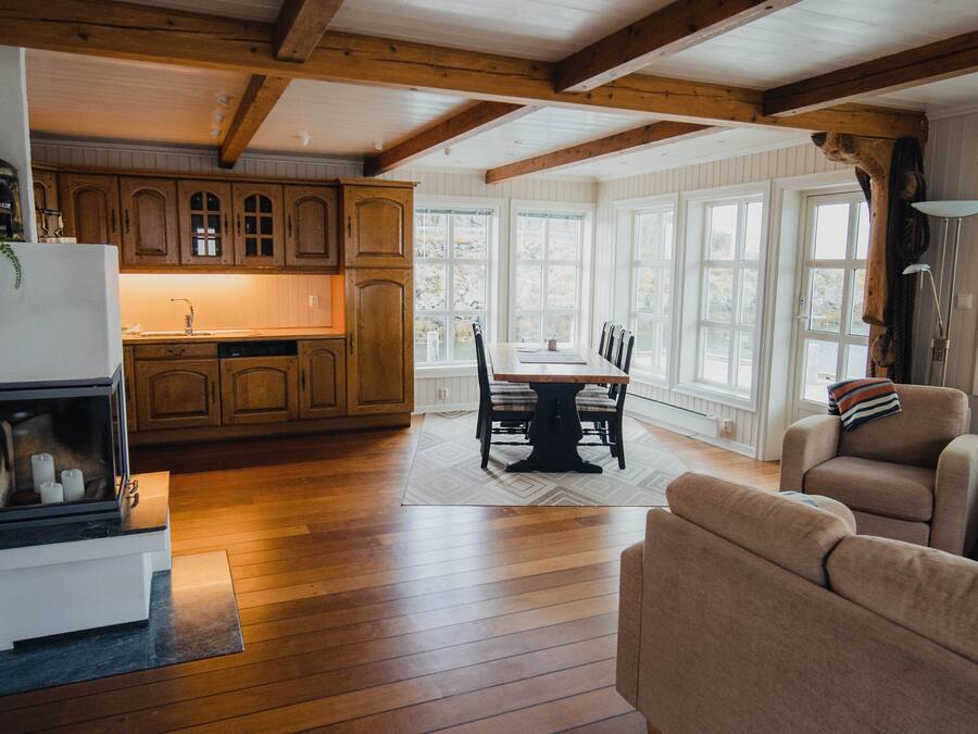 A spacious kitchen with wooden cabinets and a dining area with a table and chairs.