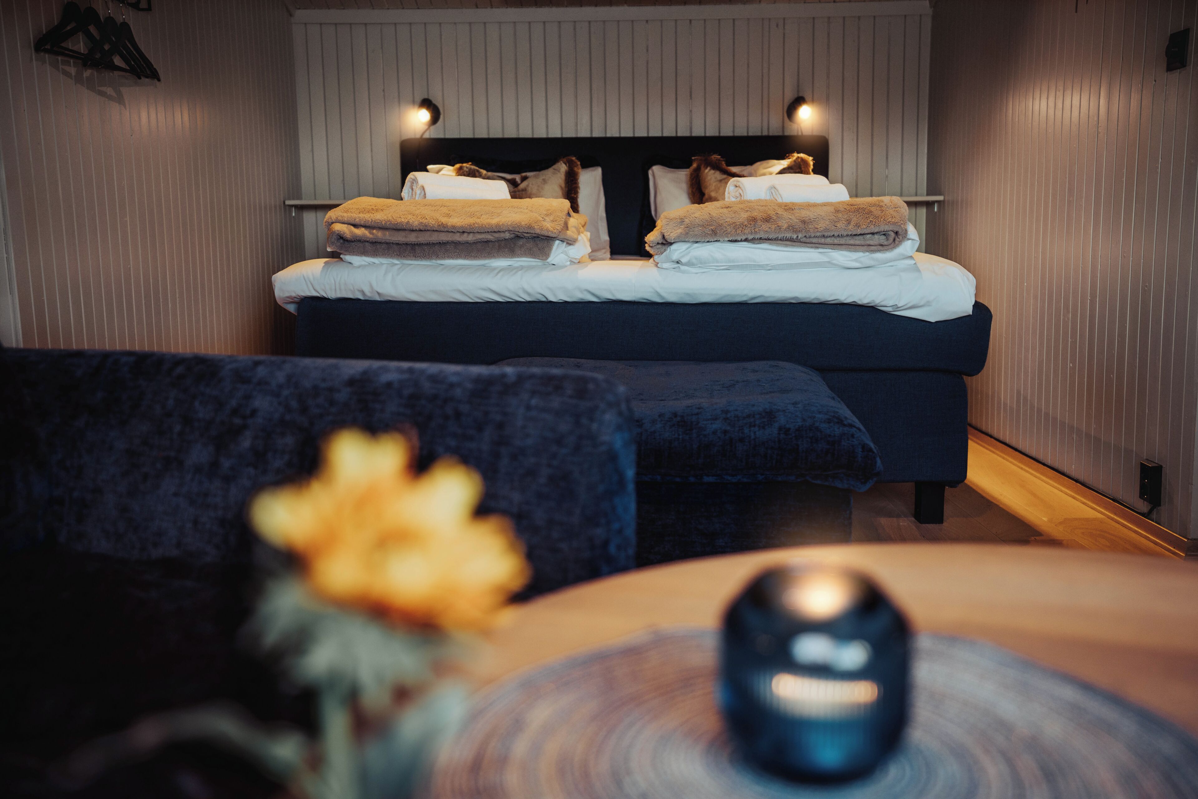 Un dormitorio con cama, lámparas de noche, mesita de noche y una silla.