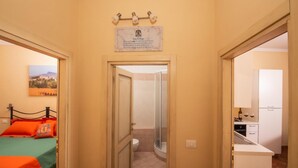 Habitación de hotel con cama, baño y kitchenette.