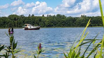 Ein Boot auf einem See mit bewaldeter Uferlinie.