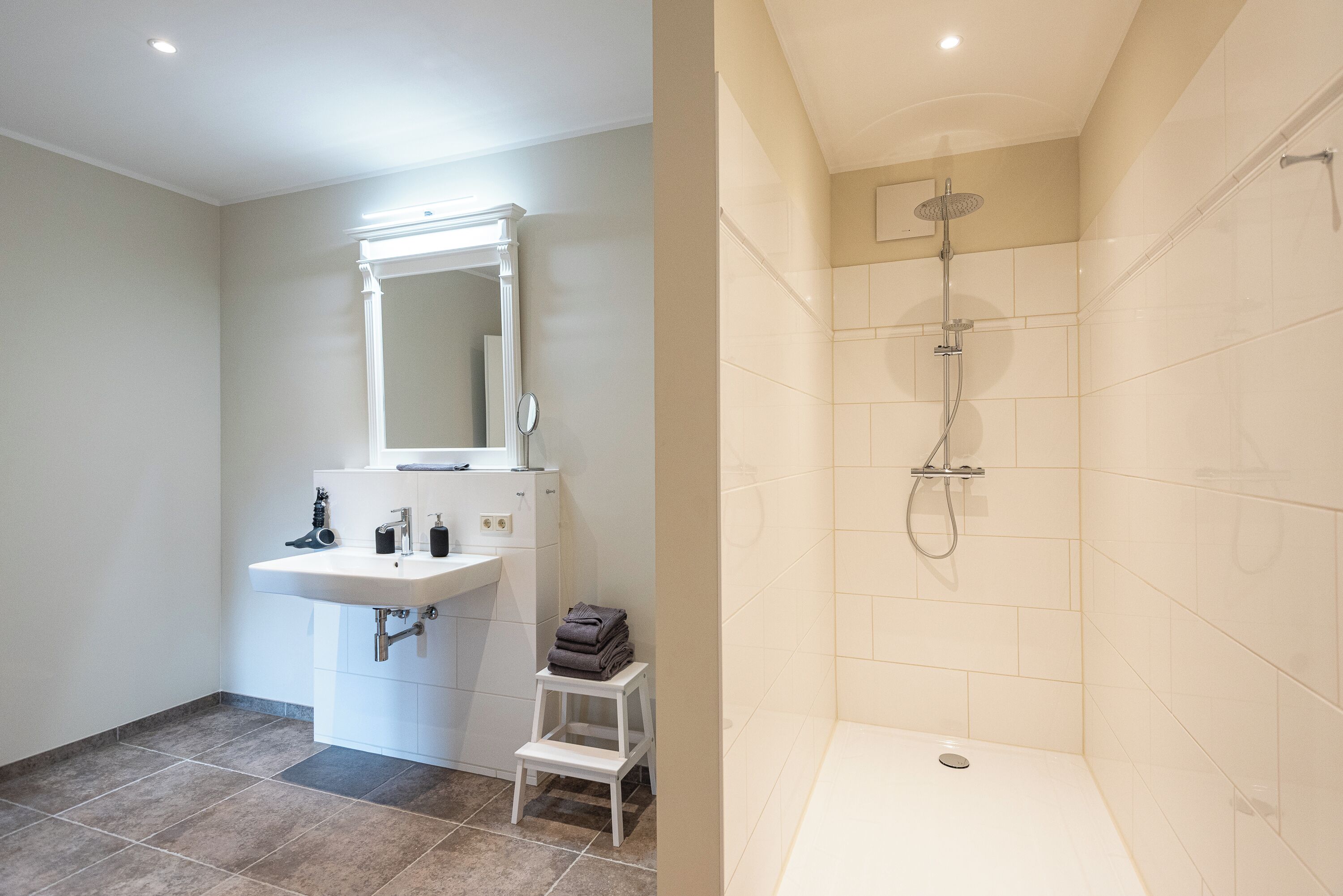Ein Badezimmer mit Waschbecken, Spiegel und Dusche.