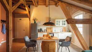 A dining area with a wooden table, four chairs, and a hanging light fixture.