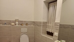 Une salle de bain équipée d’un bidet, de toilettes et d’un lavabo.