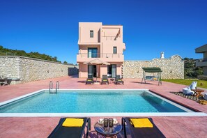 A modern two-story building with a pool, outdoor seating, and a stone wall. - Alki Slow Living - Alkinoe (Afandou)