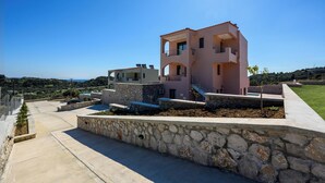 A modern multi-story house with a stone retaining wall, a pool, and a clear view of the sea. - Alki Slow Living - Alkinoe (Afandou)