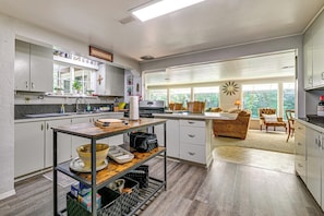 Una cocina moderna con comedor, ventanas amplias y vistas al exterior.