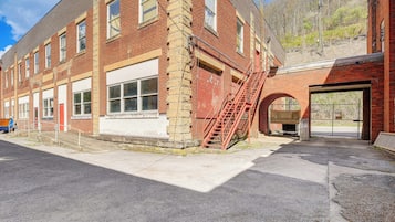 A brick building with a fire escape, a garage door, and a clear sky.