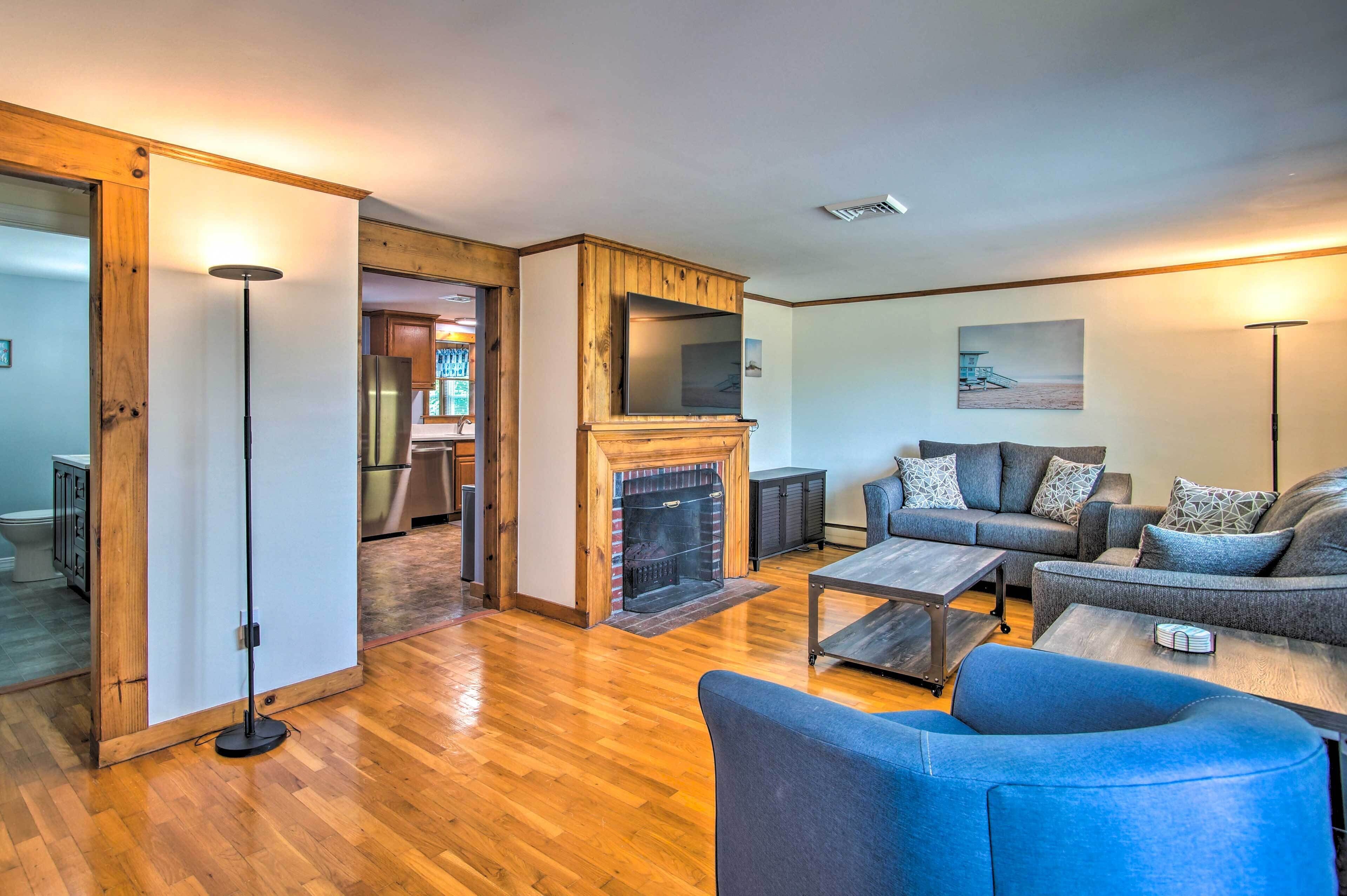 A modern living room with a fireplace, a sofa set, and a coffee table.