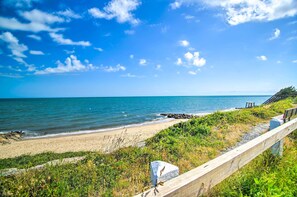 A beach with a wooden fence, a rocky outcrop, and a clear blue sky. - Pet-Friendly Yard! Fun Family Home in Cape Cod (Dennis Port)