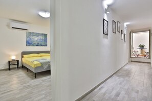 Ein modernes Schlafzimmer mit Bett, Nachttisch und einem Bild an der Wand.