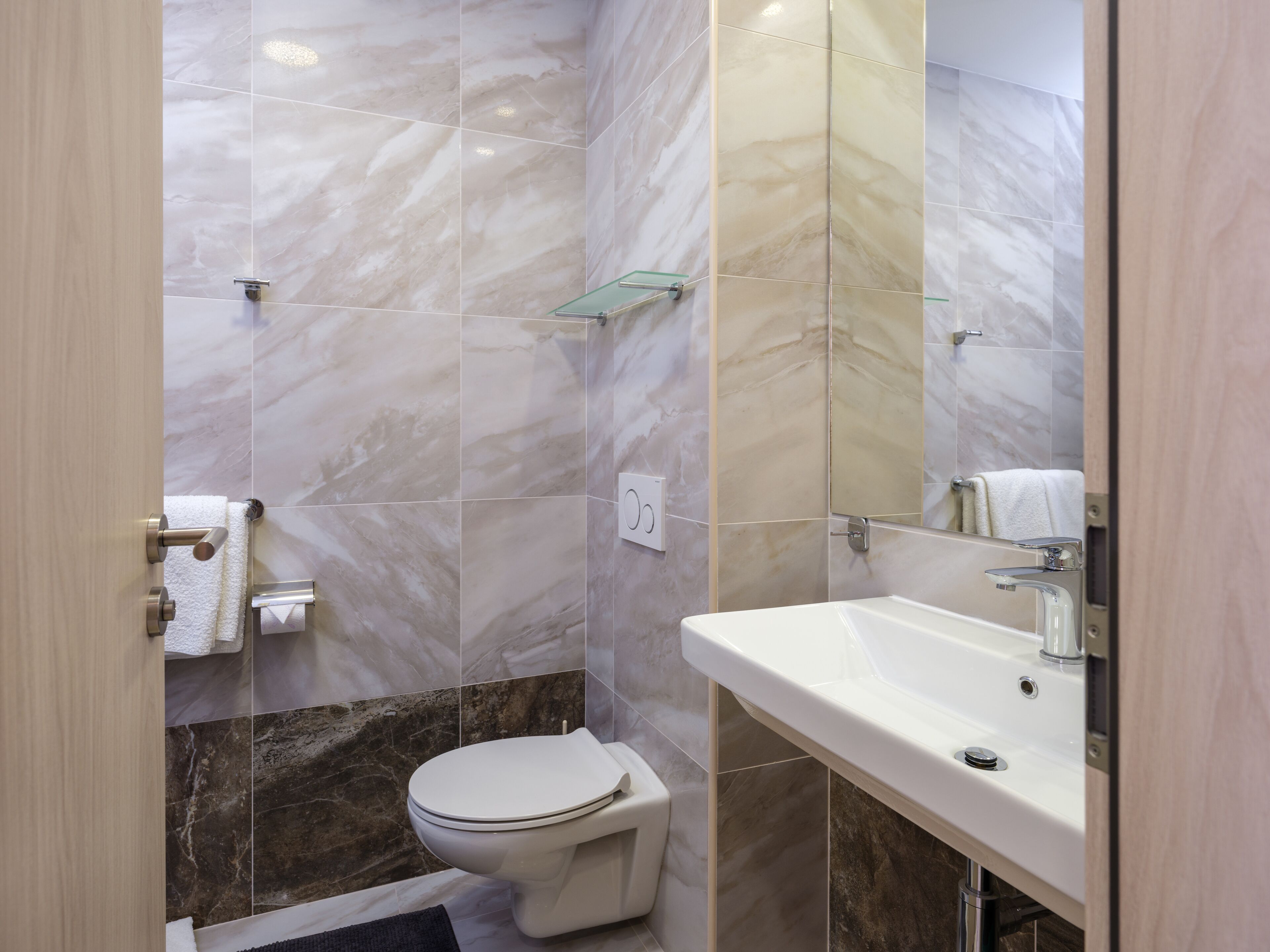 Un baño con inodoro, lavamanos y espejo.