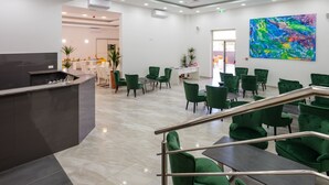 A modern lobby with a reception desk, green seating area, and a colorful abstract painting on the wall. - Hotel D-Elegant Dubrovnik (Dubrovnik)