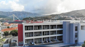 Um hotel com design moderno, com várias varandas e vista para a paisagem ao redor.