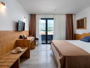A hotel room with a bed, a desk, a chair, a TV, and a view of the outdoors. - Hotel D-Elegant Dubrovnik (Dubrovnik)