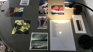 A round table with various artworks and a list of names, possibly indicating an art exhibition or event.