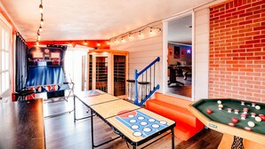 Une pièce équipée d’une table de billard, d’un baby-foot et d’une table de ping-pong.