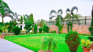 A well-maintained garden with a variety of plants and a stone wall. - The Pure Nature Hotel (Rajgarh)