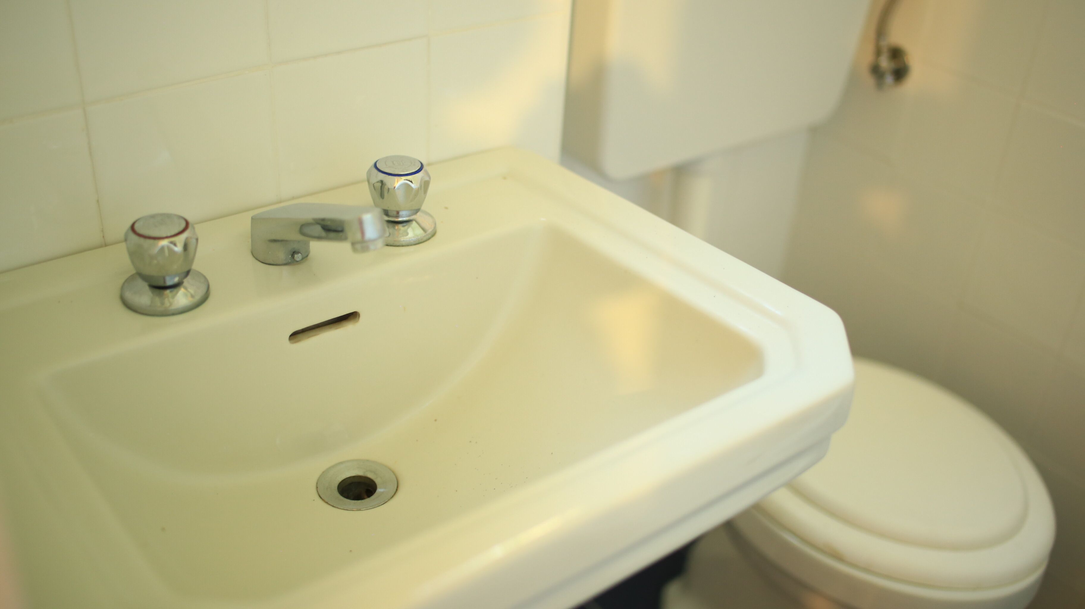 Ein Badezimmer mit Waschbecken, Wasserhahn und Toilette.