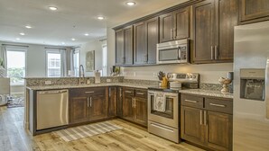Una cocina moderna con gabinetes de madera oscura, electrodomésticos de acero inoxidable y encimera de granito.
