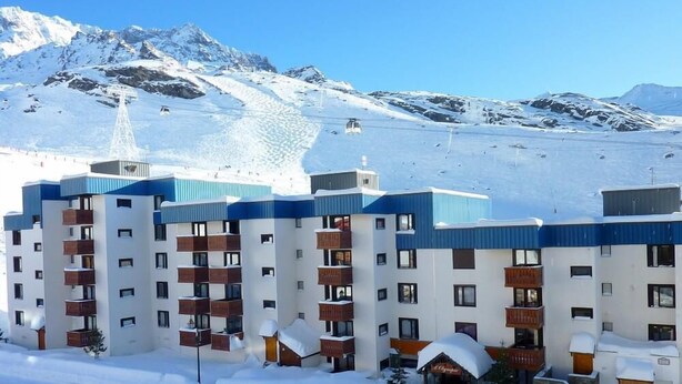 A snow-covered hotel with multiple floors, balconies, and a ski lift in the background. - 50m from ski slopes, 4th floor, balcony, ski locker, 39m², Val Thorens (Val Thorens)