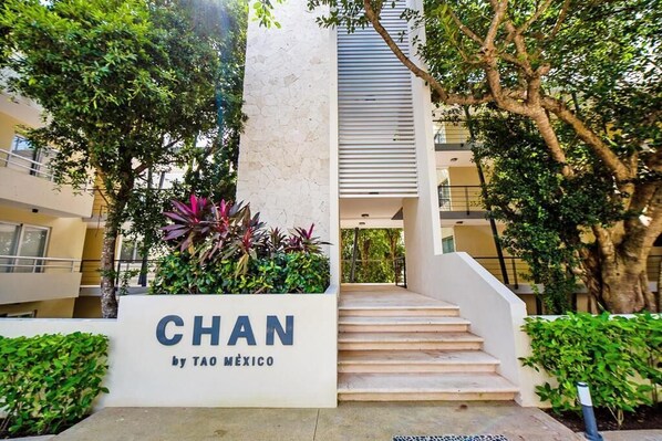 A staircase leading to a building entrance with a sign that reads 'CHAN by TAO MÉXICO'.