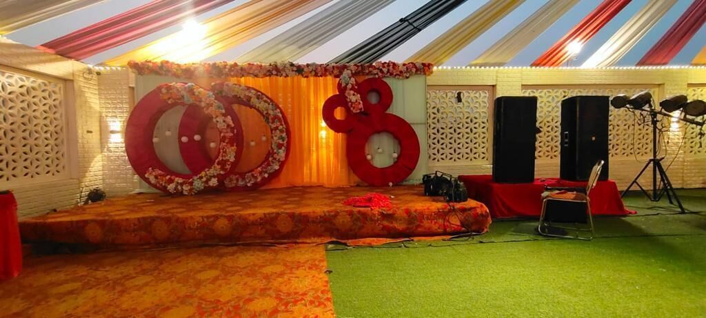 Un escenario con un fondo floral, grandes números rojos y equipo de sonido.