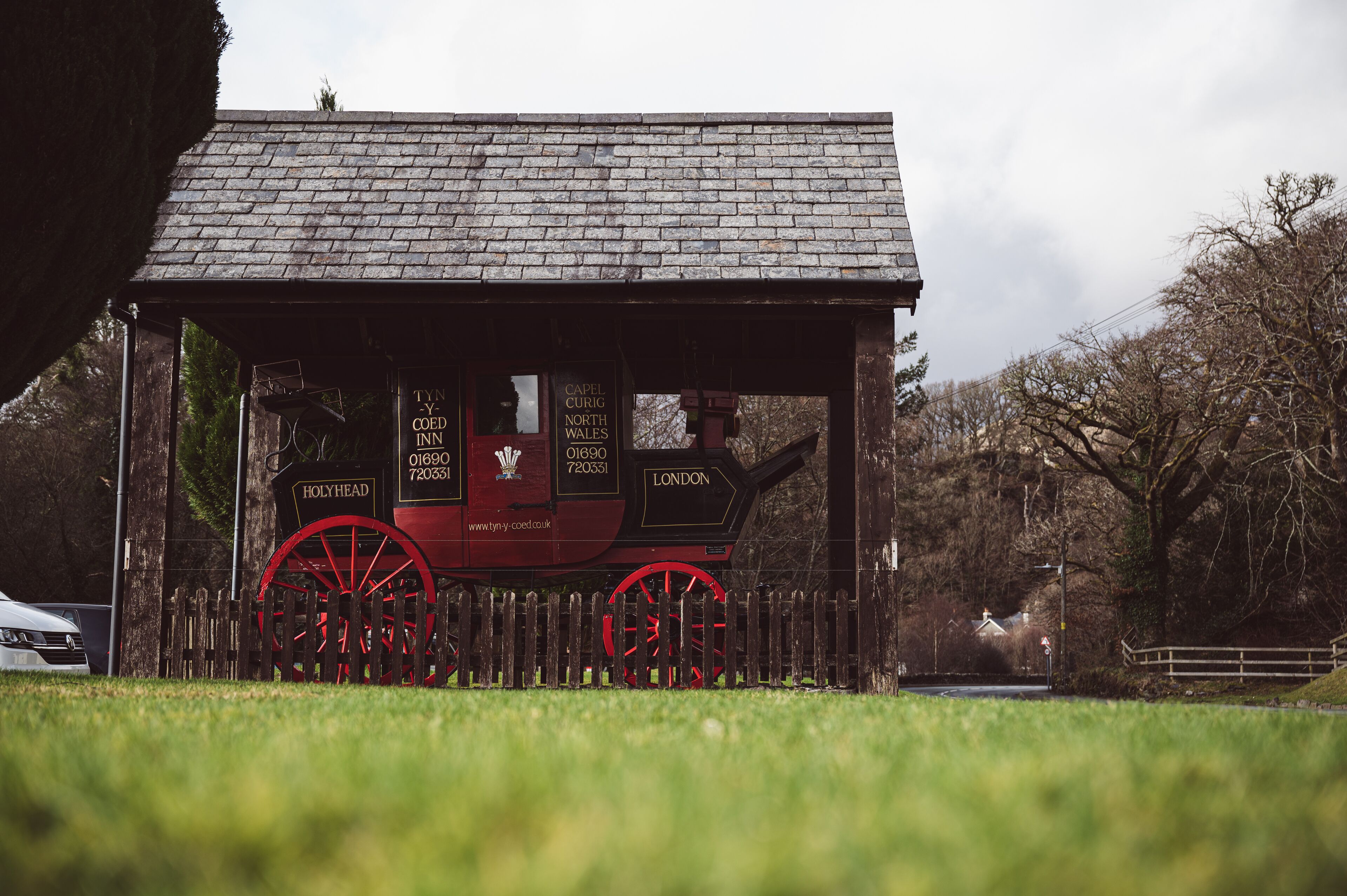 Een traditioneel gebouw in rood en zwart, met een bord waarop staat dat het de Capel Curig North Wales Inn in Londen is.