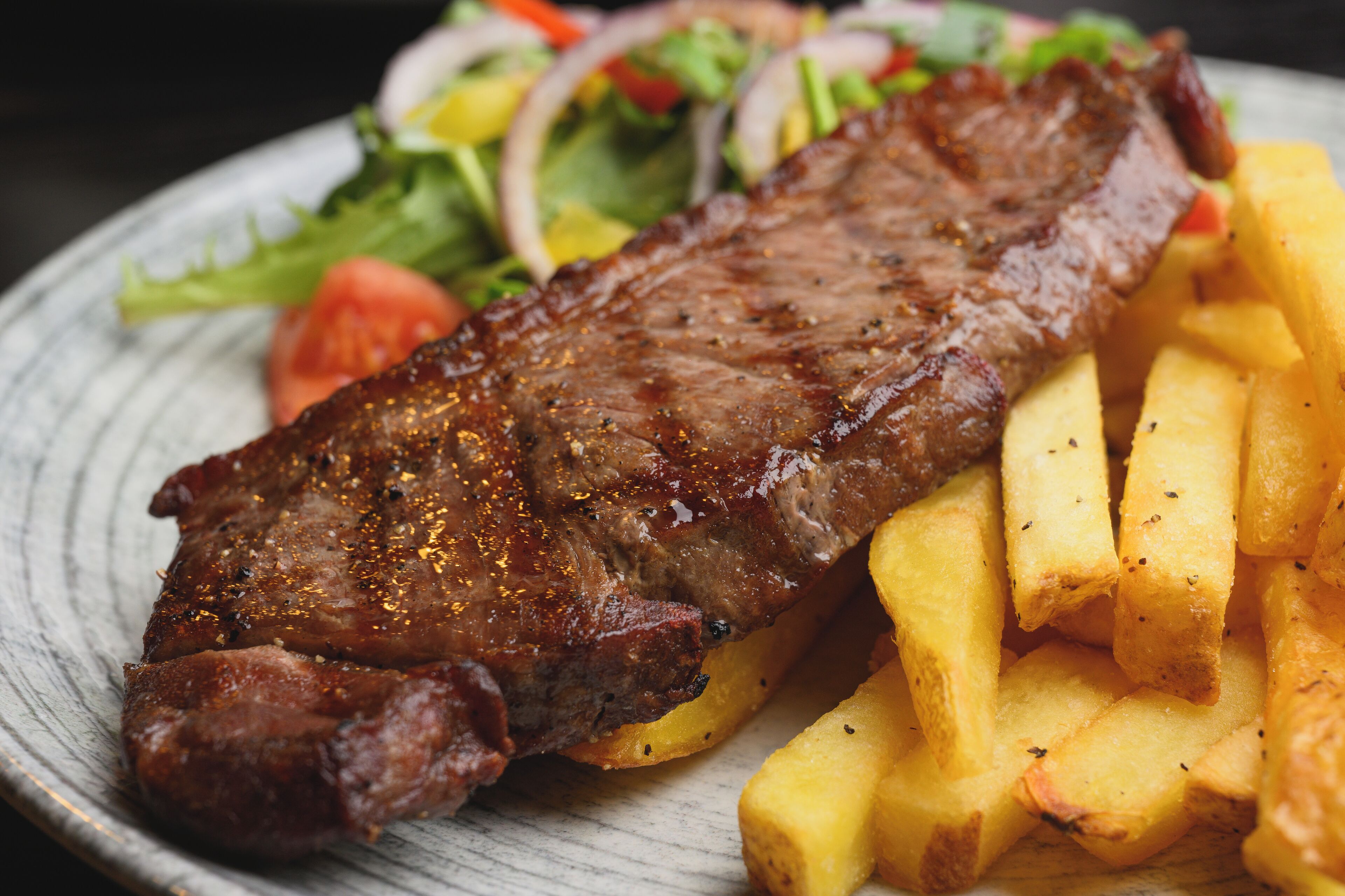 A plate with a steak and fries.