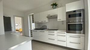A modern kitchen with white cabinetry, a stainless steel oven, and a built-in microwave. - Casa Lara in Menaggio, with pool and beautiful lake view! (Menaggio)
