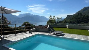 A swimming pool with a view of mountains and a lake. - Casa Lara in Menaggio, with pool and beautiful lake view! (Menaggio)