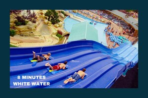 A water slide with multiple lanes, a pool area, and a beach with lounge chairs.