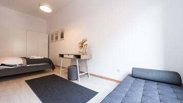 Een moderne slaapkamer met een bed, een bureau en een bank.