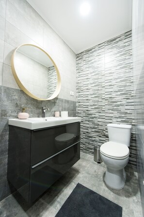 Regadera, secadora de cabello, toallas, papel de baño 