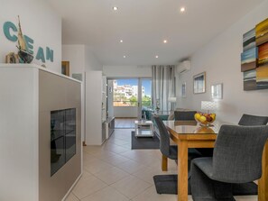 A modern living room with a dining area, a kitchen, and a balcony with a view. - Apartment Henri - Perfect couples getaway! (Lagos)