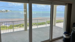 En balkong med utsikt över havet och en strand.