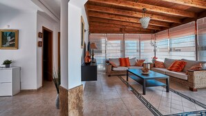 A spacious living area with a high wooden ceiling, a sofa set, a coffee table, and a fireplace. - Casa Anna, modern with rustic design (Costa Calma)