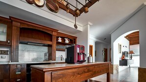 A modern kitchen with wooden cabinets, a stainless steel refrigerator, and a red coffee maker on a wooden table. - Casa Anna, modern with rustic design (Costa Calma)