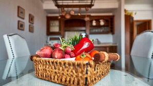 A wicker basket with vegetables on a table in a kitchen. - Casa Anna, modern with rustic design (Costa Calma)