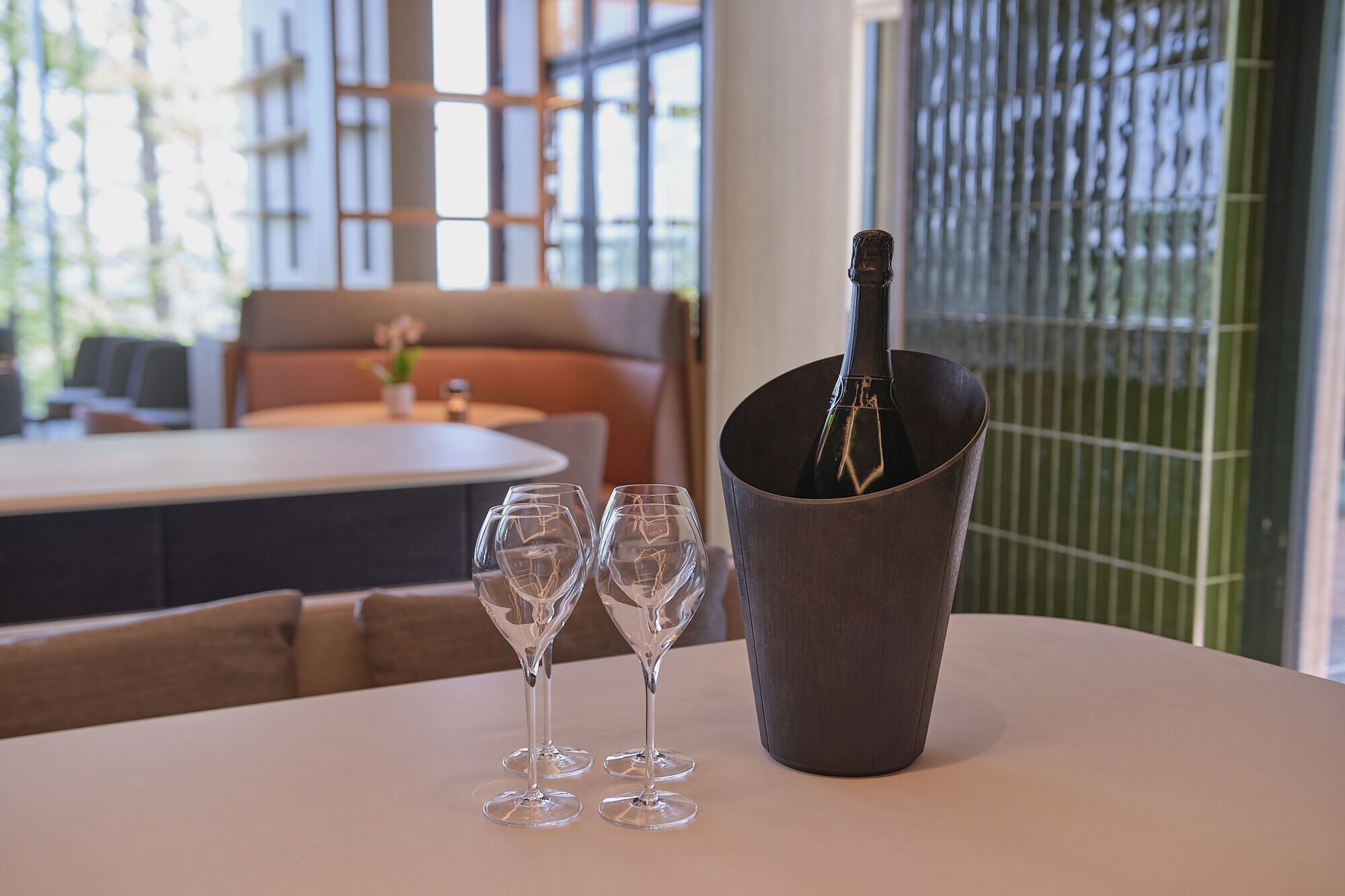 Et bord med en champagneflaske i en spand og to tomme vinglas.