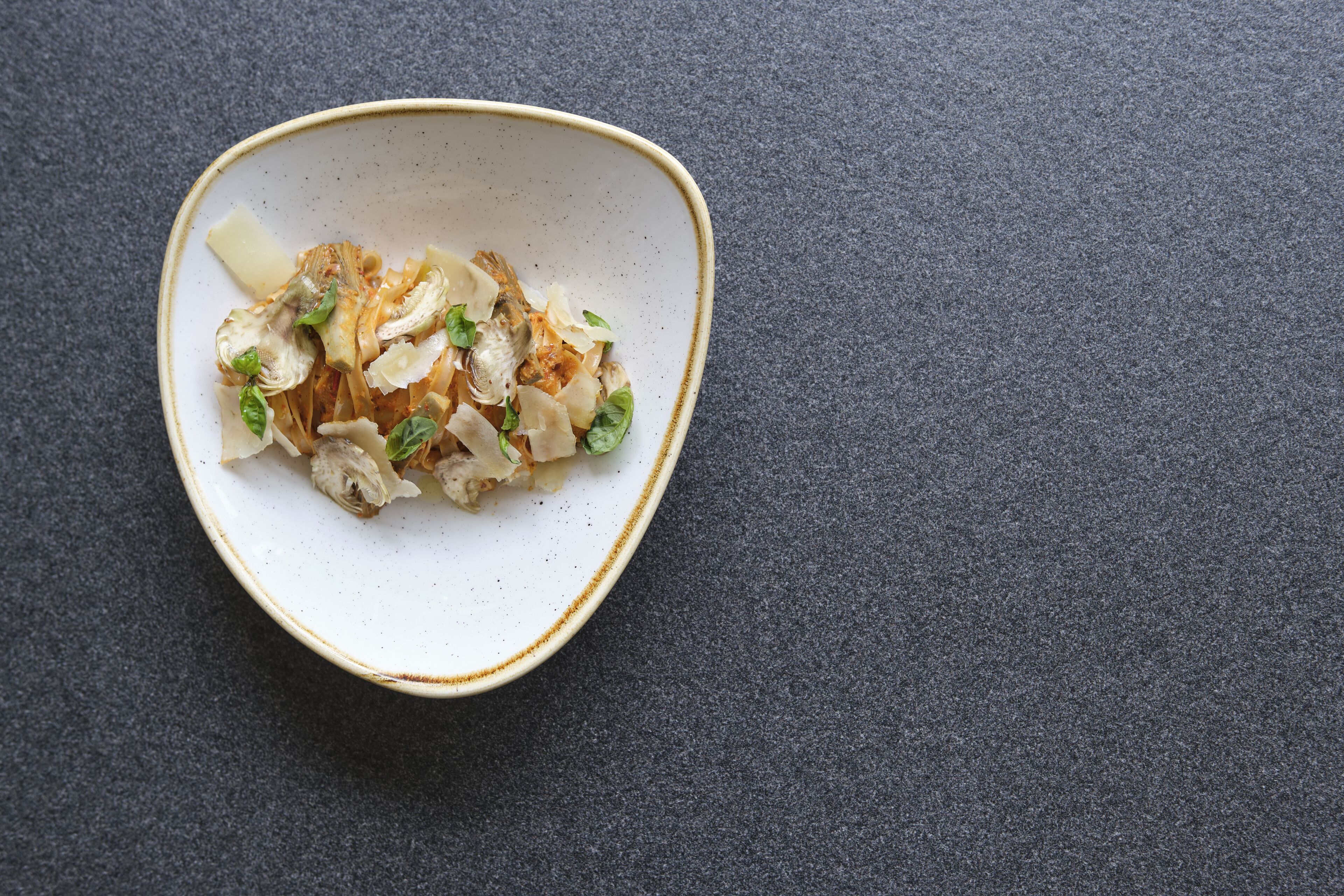 A bowl of food on a dark surface.