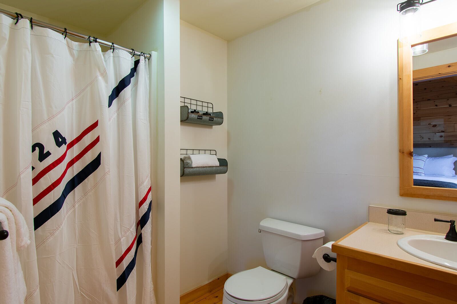 Une salle de bain équip ée d’un rideau de douche, de toilettes, d’un lavabo et d’un porte-serviettes.