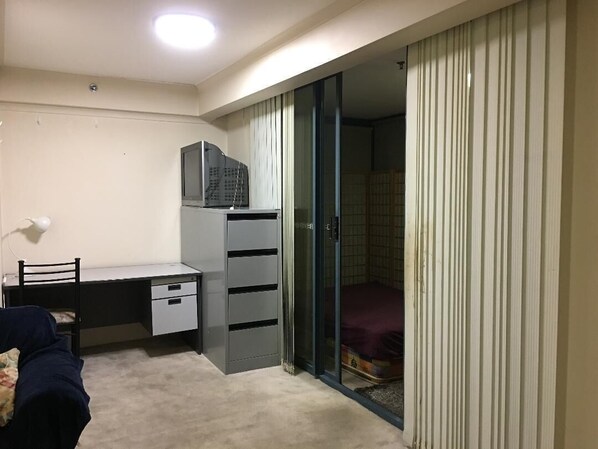 Cozy retreat with a single bed, desk, and lamp, perfect for a functional stay.