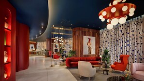 Un intérieur moderne avec un mur d’accent rouge, un grand canapé rouge et un luminaire au plafond original.