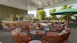 Un espace extérieur aménagé avec des meubles en osier, un bar et une vue sur la ville.