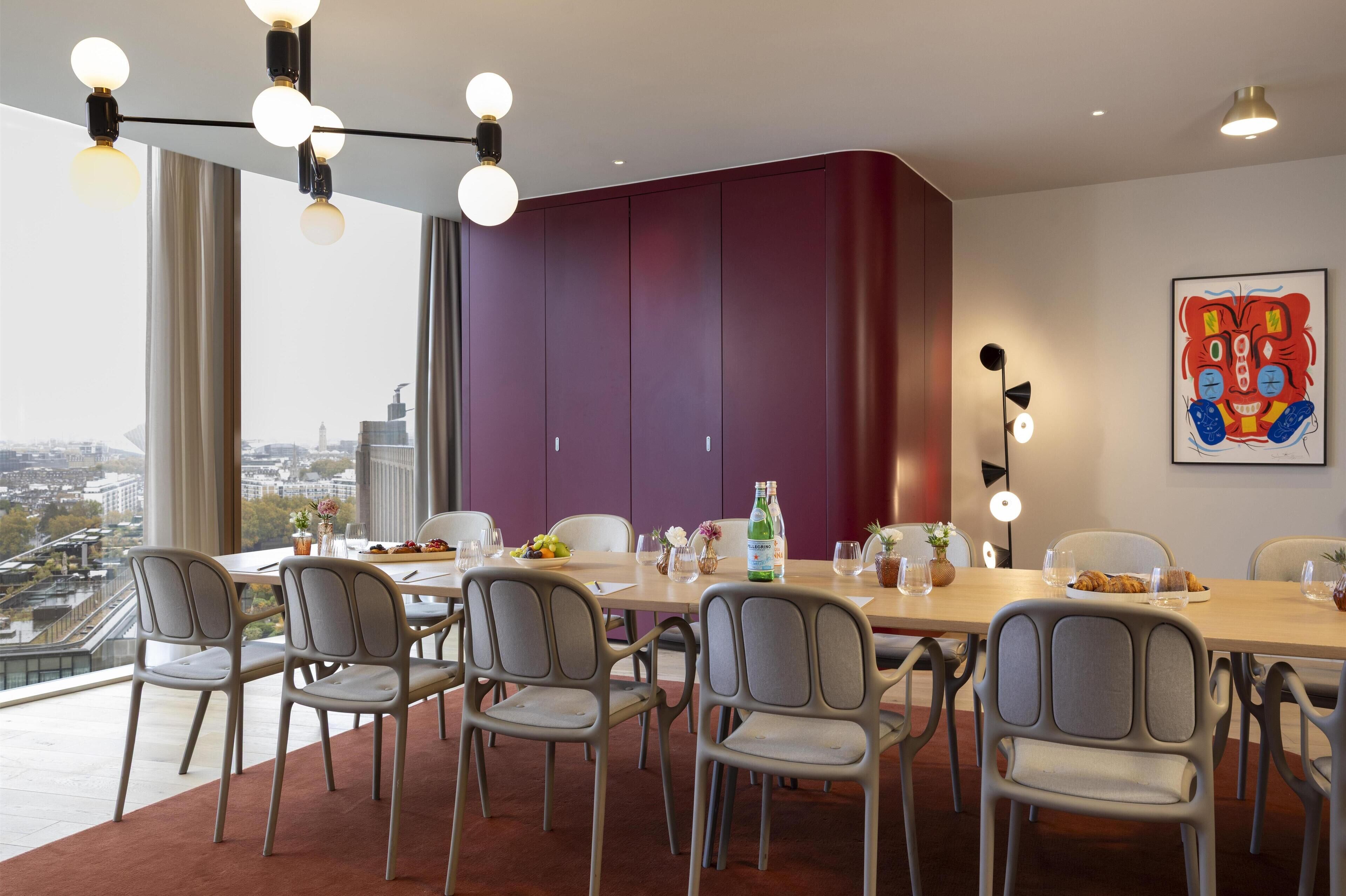 A modern dining area with a large table, chairs, and a city view.