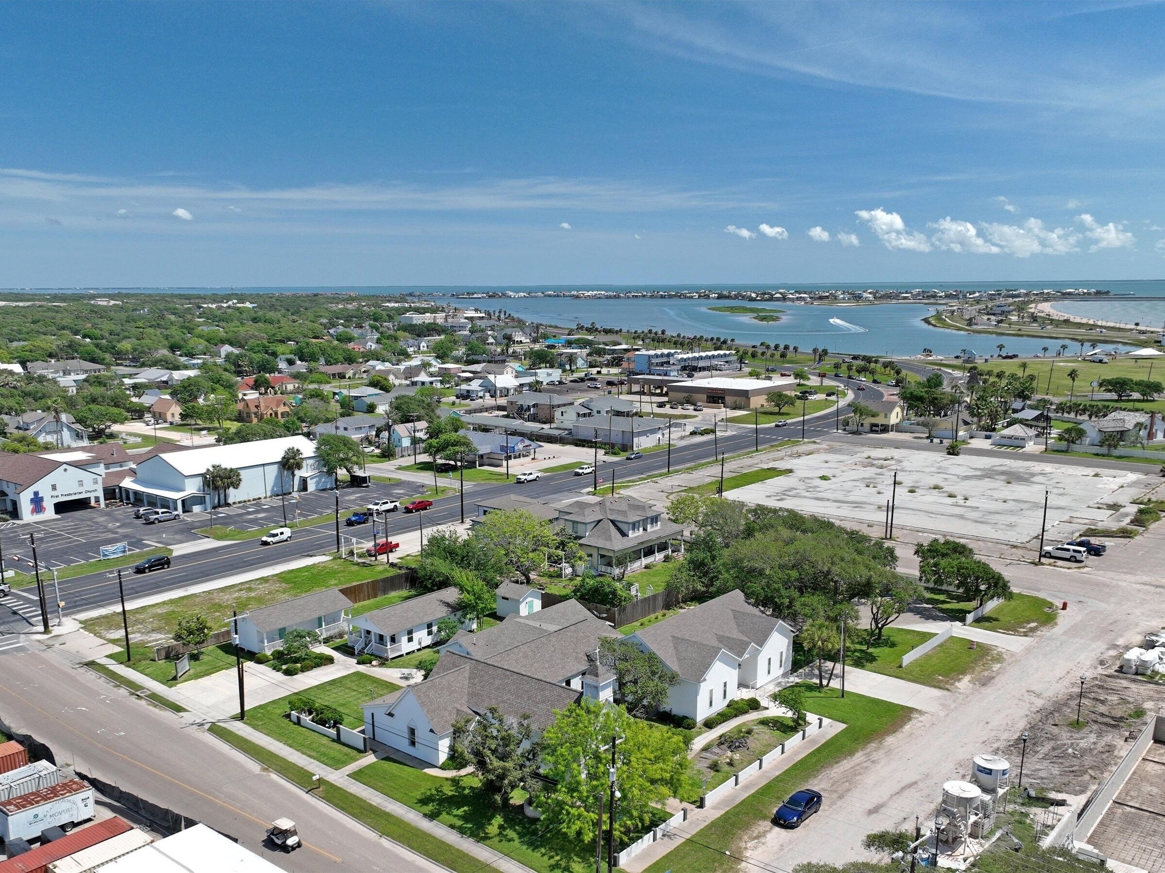 A residential area with houses, a church, and a large parking lot.