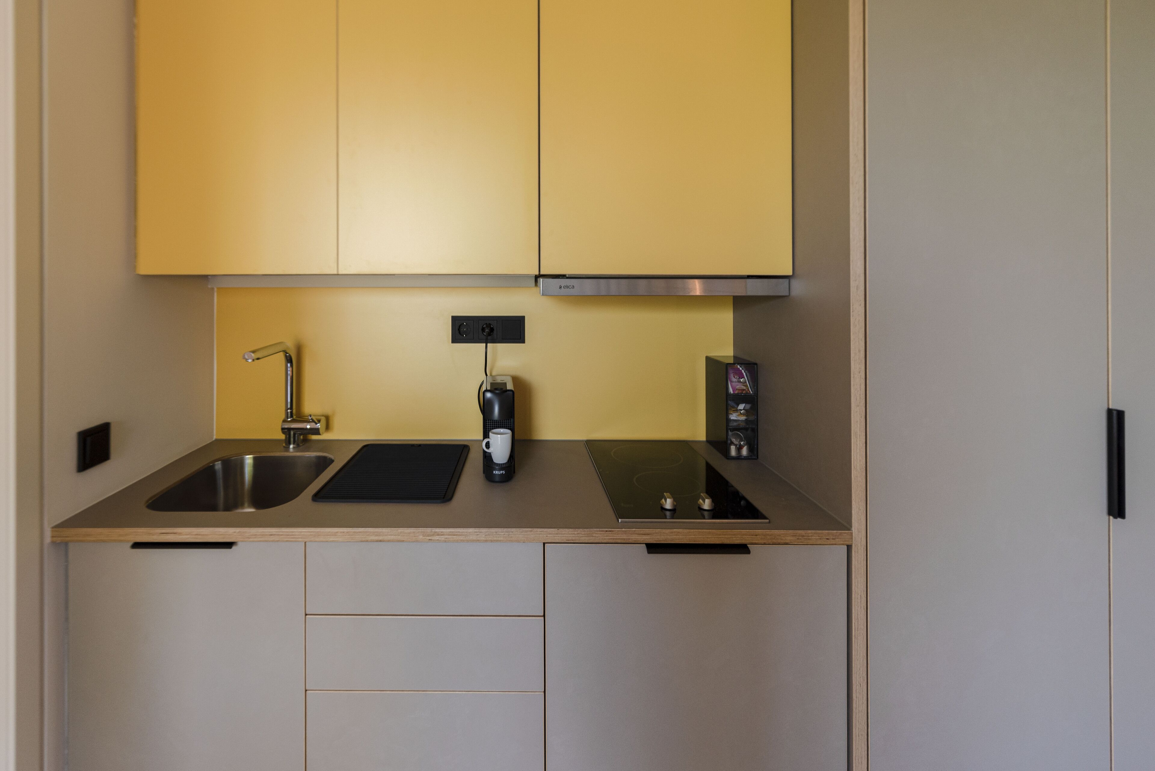 A modern kitchen with stainless steel appliances, a double sink, and wooden cabinetry.